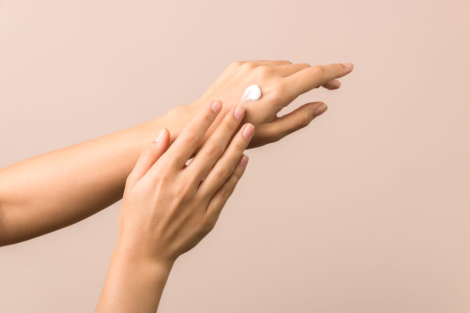 Hand wird mit Pflegecreme eingecremt